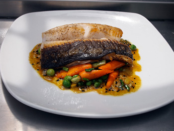Pan-seared Black Cod with peas, carrots and curry mint vinaigrette prepared by Chef Mark Dommen of One Market Restaurant in San Francisco