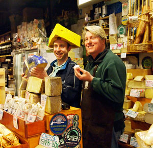 Kent Torrey of The Cheese Shop in Carmel with a silly customer wearing a tri-corn cheese head hat